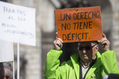 Un pensionista leonés sostiene una pancarta durante una protesta. FERNANDO OTERO