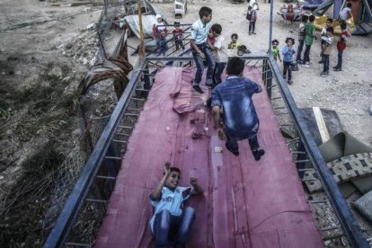 Niños sirios juegan en un trampolín durante el segundo día de la festividad musulmana de Eid Al Adha, en Douma, este martes.