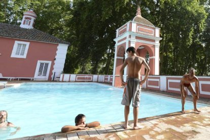 Jornaleros se bañan en la piscina del Palacio de Moratalla, tras ser ocupada la zona ajardinada.