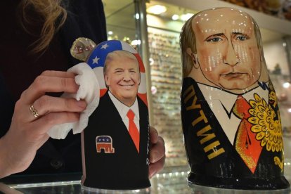 La empleada de una tienda de 'souvenirs' de Moscú saca brillo a las matrioskas de Trump y Putin, a cuatro días de la investidura del primero como presidente de EEUU.