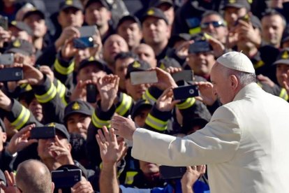 El Papa Francisco rodeados de fieles que alzan sus télefonos móviles