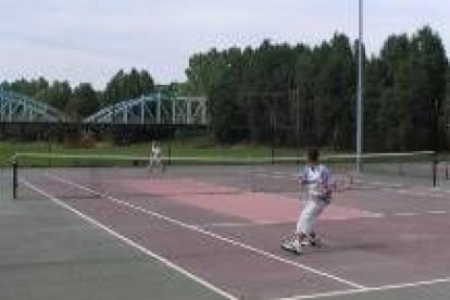 Dos jóvenes deportistas disputan un partido de tenis