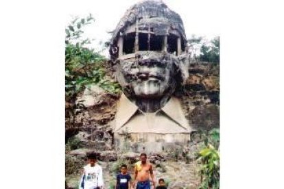 Unos turistas pasan por las ruinas de la estatua del ex dictador Filipino