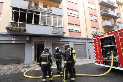 Los bomberos, junto a la vivienda que ardió. MARCIANO PÉREZ