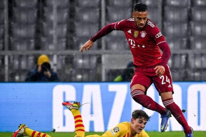 Tolisso se lleva el balón frente a Gavi que queda tendido en el césped. PHILIPP GUELLAND