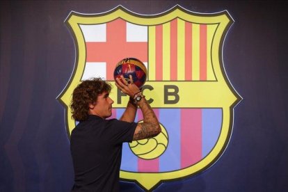 Griezmann simula tirar a canasta tras el posado en la tienda del Barça junto al Camp Nou.