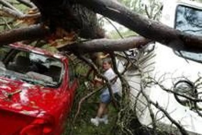 Una mujer observa los destrozos que «Iván» ha dejado en su camioneta y en el coche de a lado