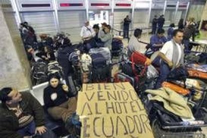 Unos pasajeros de Air Madrid esperan junto a su equipaje en Barajas