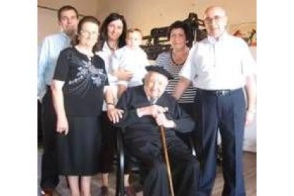 Pedro y su familia, tras recibir el bastón centenario, posan en el taller frente al telar