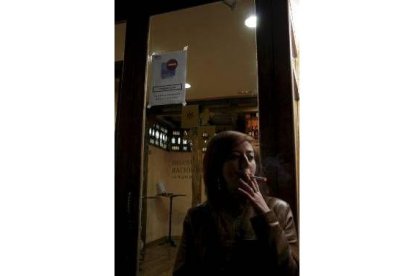 Una trabajadora fuma un cigarrillo a la puerta de un centro