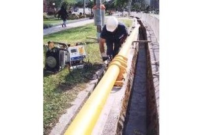 Un obrero instala las tuberías conductoras del gas