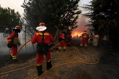 Efectivos de la Unidad Militar de Emergencias (UME) trabajan en la extinción del incendio, declarado ayer en los municipios abulenses de Navalacruz y Cepeda de la Mora y La Parra, este domingo en la localidad abulense de Robledillo. EFE/Raúl Sanchidrián