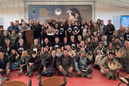 Foto de familia con los ganadores y organizadores, uno de los cetreros participantes y una de las aves rapaces en concurso. FERNANDO OTERO