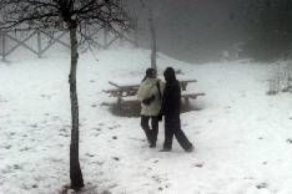 Una pareja pasea por los alrededores del Santuario de la Font Roja en Alcoy disfrutando de la nieve