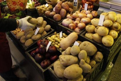 Patatas y otros productos en la parada de un mercado de Barcelona.