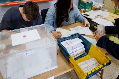 Una empleada de Correos entrega votos por correo en una de las mesas de un colegio electoral. NACHO GALLEGO