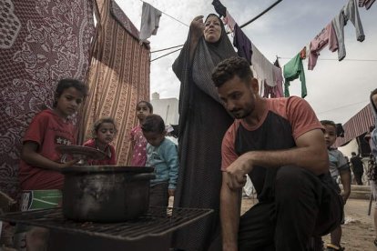 Palestinos cocinan en un campamento habilitado por Naciones Unidas en Khan Yunis para desplazados por los bombardeos. HAITHAM IMAD