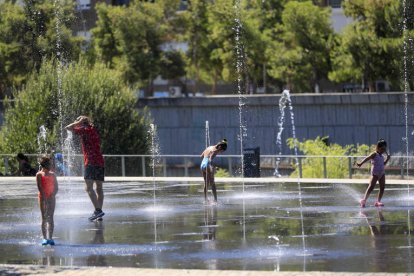 Varias personas se refrescan en la zona de Madrid Río. FERNANDO ALVARADO