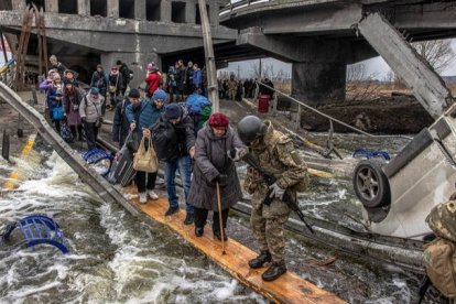 Civiles ucranianos cruzan un puente destruido mientras huyen del asedio en la ciudad de Irpin. ROMAN PILIPEY