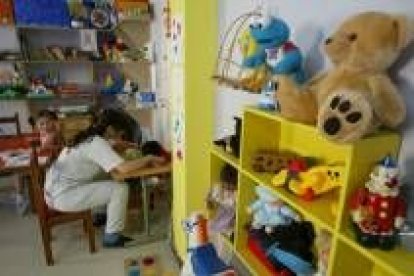 Una trabajadora de Aspace atiende a dos niños afectados por parálisis cerebral