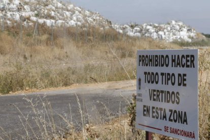 Un cartel avisa contra los vertidos en la finca de El Busto, de donde se extraen las balas.