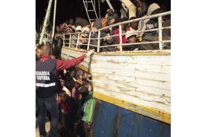 Guardias costeros ayudan a una embarcación recién llegada de Libia en Lampedusa (Italia).