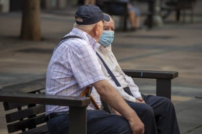 Dos hombres descansan en un banco. AGENCIAS