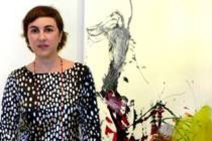 La artista Belén González posa junto a una de las obras que expone actualmente en León