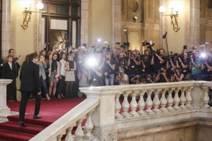 Puigdemont llega al Parlament entre una nube de fotógrafos, el martes, antes de su comparecencia en el pleno.