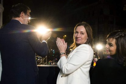 Rajoy saluda desde el balcón de Génova a los simpatizantes del PP junto a su mujer, Elvira Fernández, y Sáenz de Santamaría.