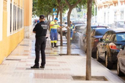 Unos operarios limpian la puerta del Colegio San Manuel en la calle Fernán Núñez de Málaga después de que un hombre, de 55 años y nacionalidad española, haya matado a su pareja sentimental de un disparo de escopeta y luego se haya suicidado con el mismo arma. EFE/Carlos Díaz.