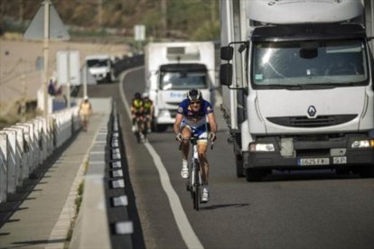 Dos camiones adelantan a unos ciclistas.