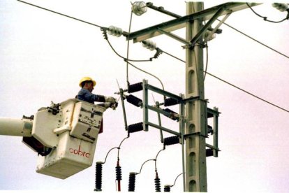 Un equipo técnico repara un poste de electricidad.