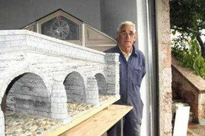 José Luis Sierra junto a la maqueta del puente viejo de Boca de Huérgano hecha en piedra y madera.