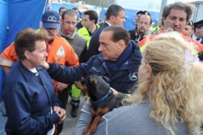 Berlusconi charla con una mujer víctima del terremoto, en el campo de evacuados de Monticchi