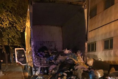 El camión de la basura en el que fue encontrado el intruso, con toda la carga esparcida en la calle.