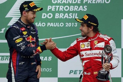 Fernando Alonso, tercero en Brasil, felicita a Sebastian Vettel por su victoria.