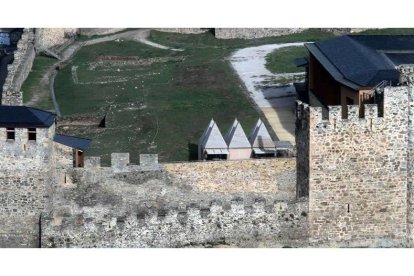 El tejado de la caseta tienda de madera instalada en el patio, en contraste con las almenas del Castillo de los Templarios.