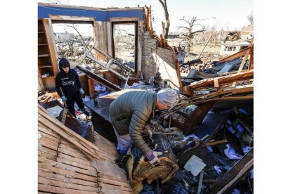 Un hombre y su hijo rebuscan entre los restos de su casa, arrasada por uno de los tornados. TANNEN MAURY