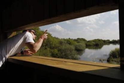 Un joven contempla la laguna desde la caseta de observación de aves.