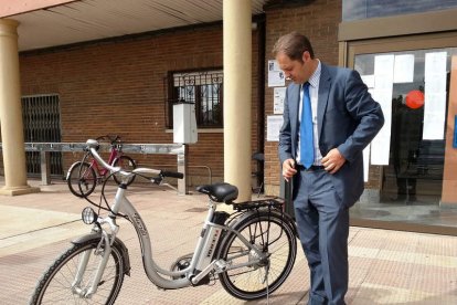 El concejal de Urbanismo y Transporte observa una de las rescatadas bicicletas eléctricas.