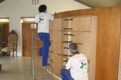 Alumnos de carpintería trabajando en la estantería.