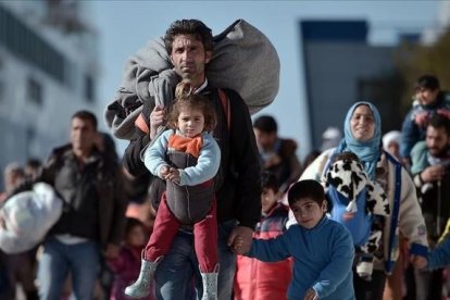 Llegada al puerto del Pireo de un grupo de inmigrantes con niños procedentes de Lesbos y Chios, el lunes.