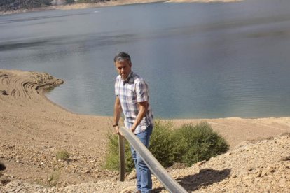 El alcalde de Riaño Fernando Moreno sujeta la tubería que llevará agua del embalse al depósito municipal. CAMPOS