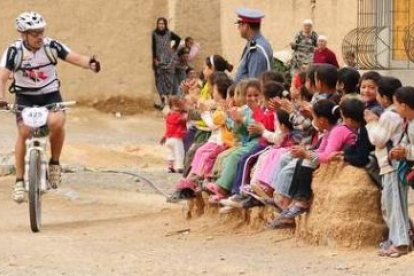 Marcos Barrio saluda a un grupo de niños durante la segunda etapa, entre Boudnib y Talsint.