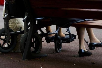 Personas mayores descansan en un banco.