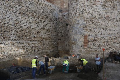 Imagen de los trabajos de excavación. A la derecha el arqueólogo municipal muestra el zócalo y la plataforma que remata la base de la muralla. FERNANDO OTERO