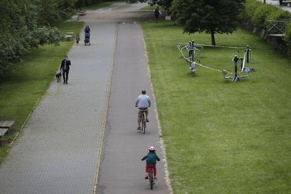 Varias personas pasean andando y en bici junto al Bernesga. JESÚS F. SALVADORES