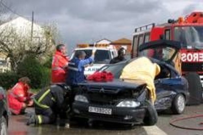 Los bomberos tratan de sacar a la mujer herida, mientras los servicios sanitarios la atienden