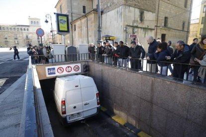 Los peatones observan la situación en la que ha quedado la furgoneta en el acceso al aparcamiento subterráneo.